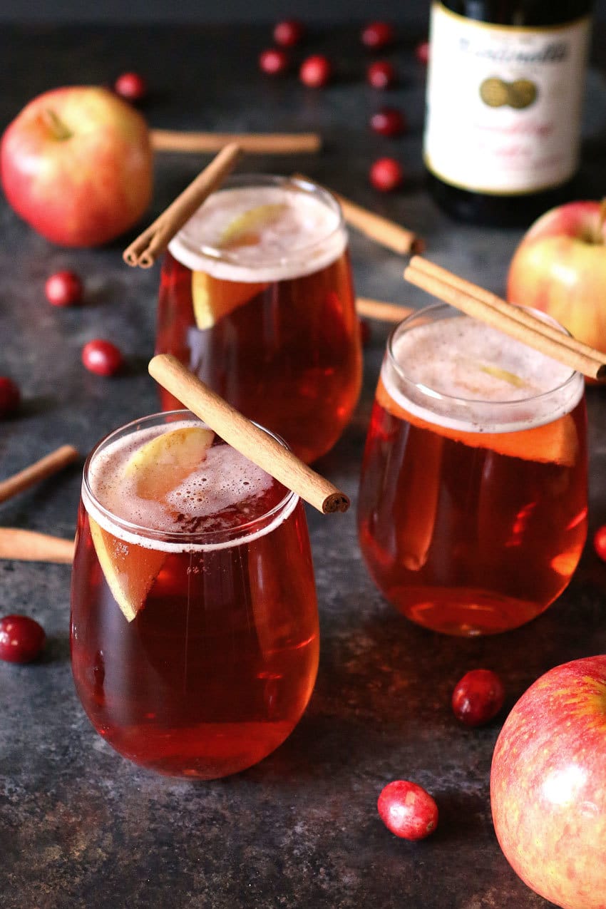 This apple cinnamon cranberry mimosa is the perfect easy holiday drink. It's main ingredient is sparkling apple cider so it can also be made into a fauxmosa! | honeyandbirch.com