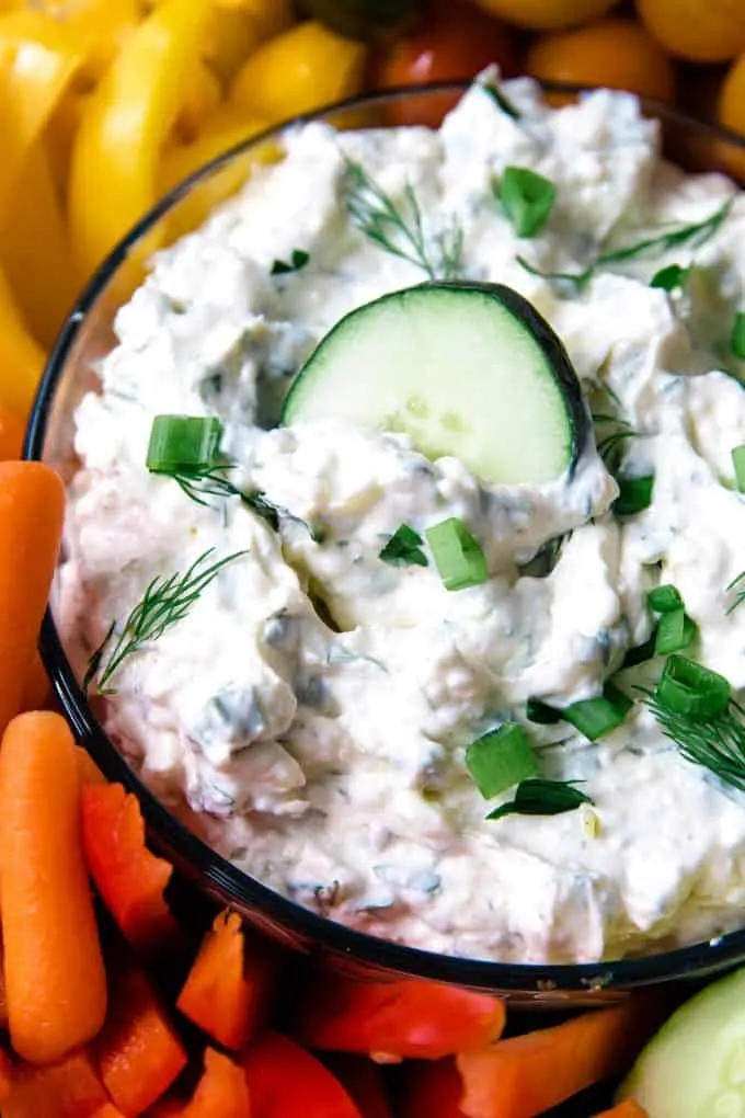 bowl of veggie dip with a cucumber slice