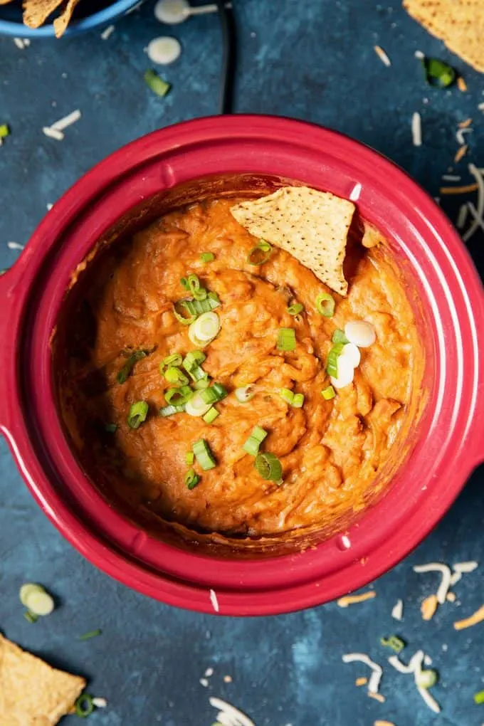 overhead picture of slow cooker bean dip on a blue table