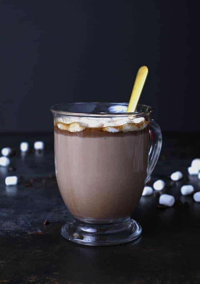 Kahlua hot cocoa in a clear mug with a gold spoon