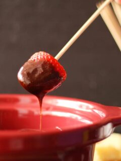 strawberry dipped into slow cooker chocolate fondue