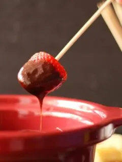 strawberry dipped into slow cooker chocolate fondue