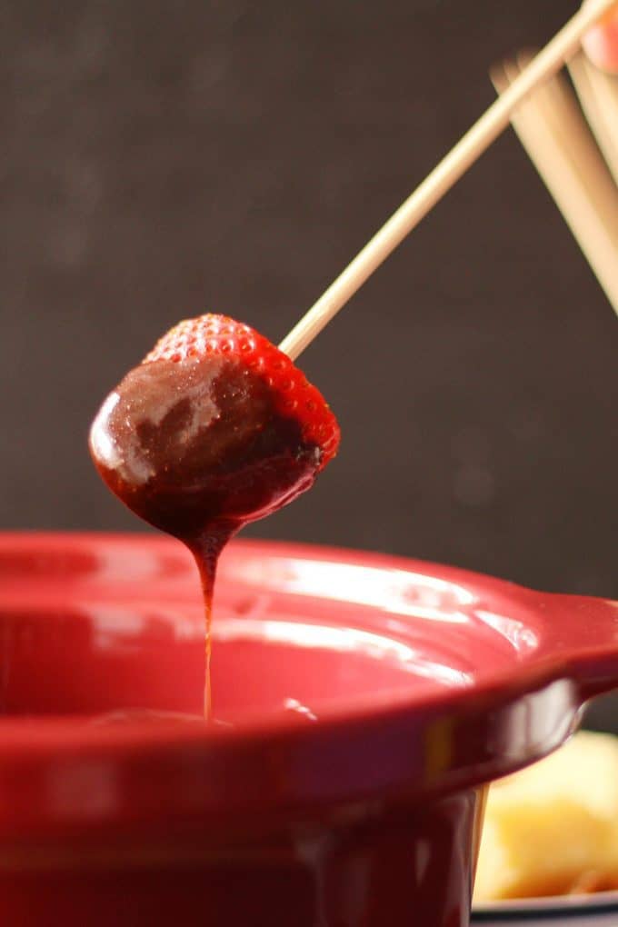 strawberry dipped into slow cooker chocolate fondue