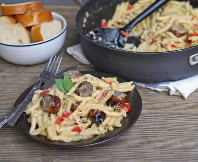 This brown butter alfredo pasta with roasted red peppers and sausage is perfect for Sunday dinner and a great way to use up leftover grilled sausage. | honeyandbirch.com