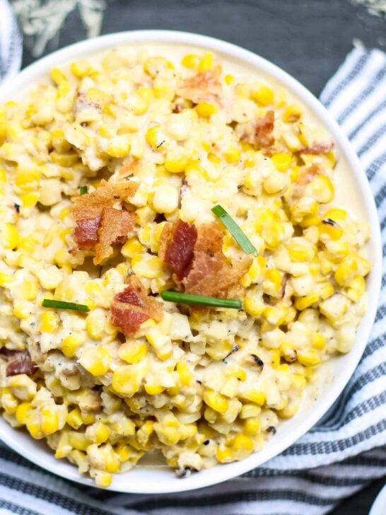 white bowl of creamed corn with a blue napkin