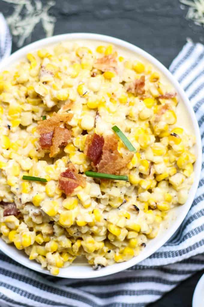 white bowl of creamed corn with a blue napkin