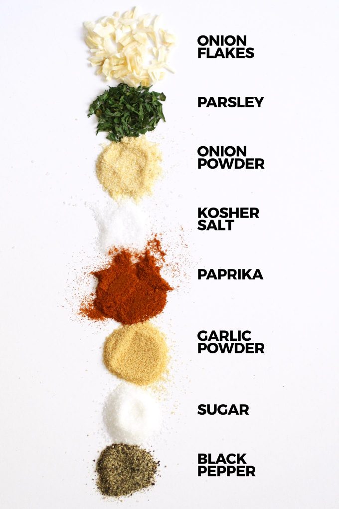 homemade onion soup mix ingredients on a white board with the ingredients labeled in black text to the right of the spices