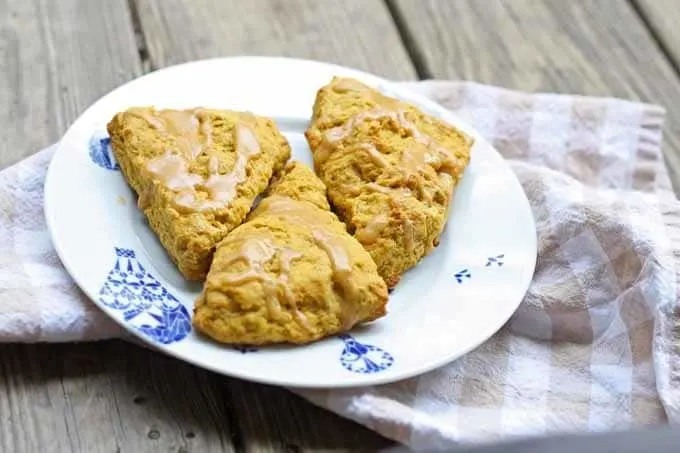 Pumpkin spice scones on a plate with a tan towel