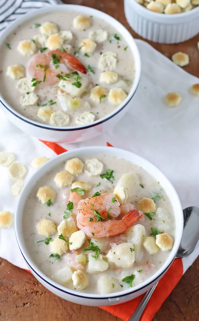 two white bowls full of potato shrimp chowder