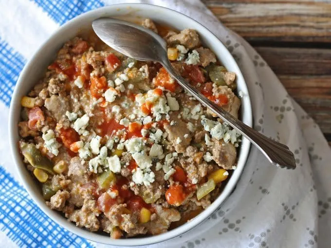 bowl of buffalo chili surround by napkins with a spoon in the bowl