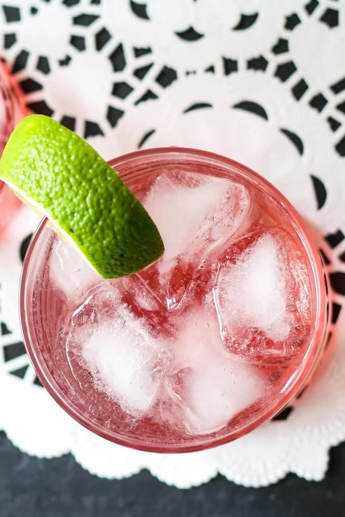 one raspberry gin spritzer garnished with a lime wedge