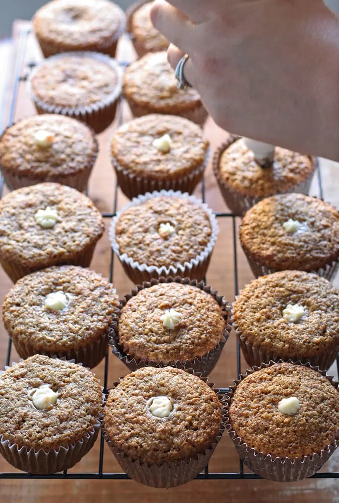 Delicious carrot cake cupcakes, filled and topped with sweet cream cheese frosting! | honeyandbirch.com