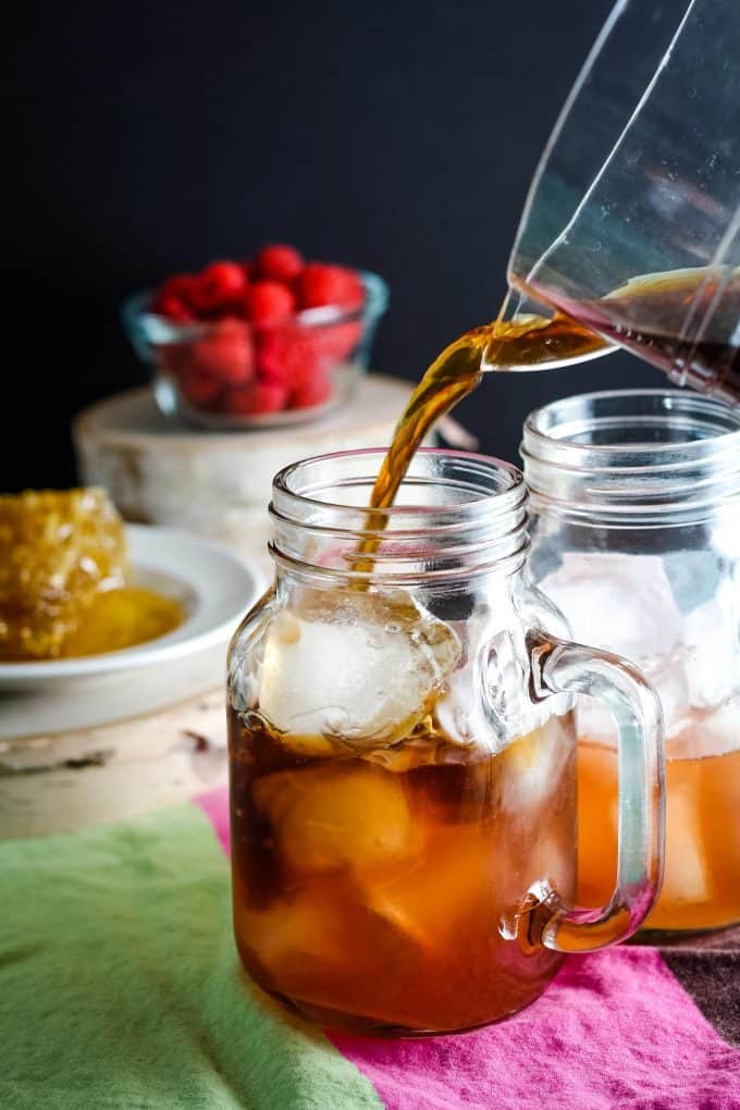 adding ice tea to mason jar mug