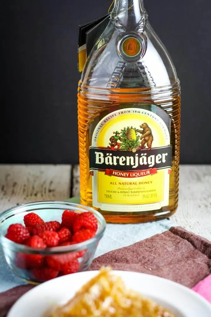 bottle of BÃ¤renjÃ¤ger with raspberries