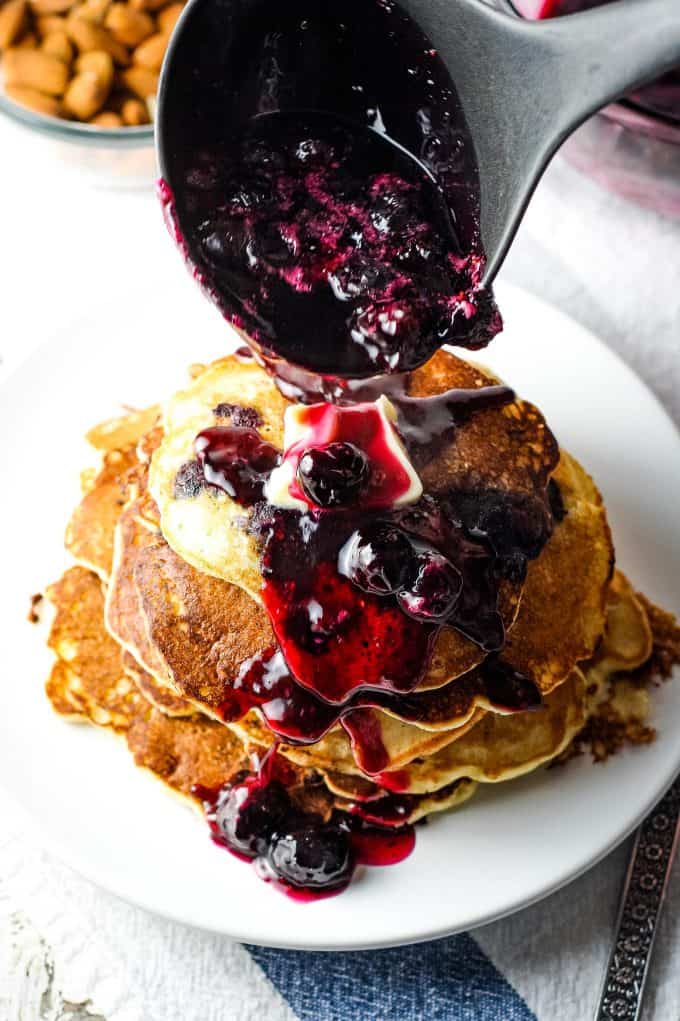 stack of pancakes with syrup being poured on top