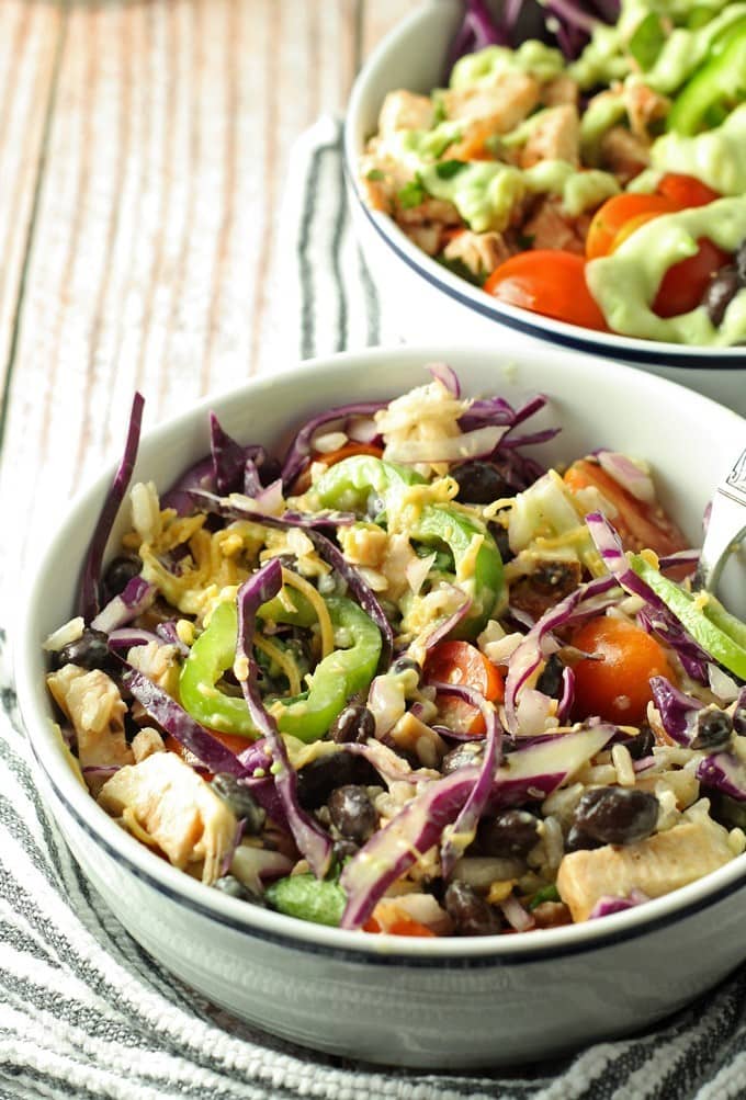 Leftover chicken burrito bowls topped with avocado crema. Full of veggies and flavor, they are the perfect use for leftover chicken! | honeyandbirch.com