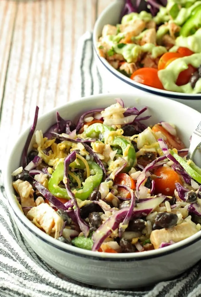 Leftover chicken burrito bowls topped with avocado crema. Full of veggies and flavor, they are the perfect use for leftover chicken! | honeyandbirch.com