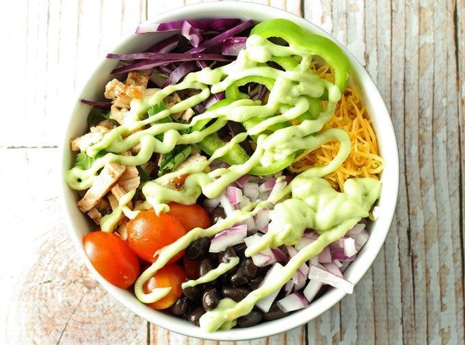 Leftover chicken burrito bowls topped with avocado crema. Full of veggies and flavor, they are the perfect use for leftover chicken! | honeyandbirch.com