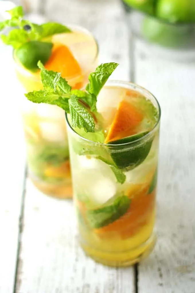 two orange mojitos on white wood