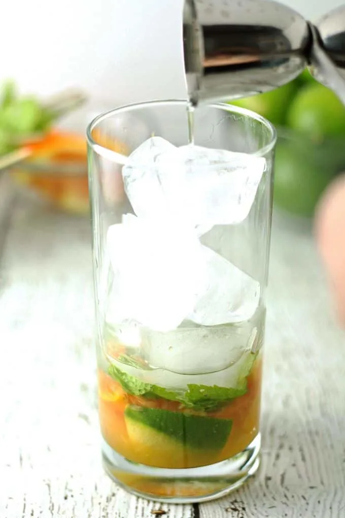 adding rum to a mojito