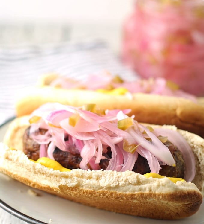 Riserva di cipolle su una salsiccia in un panino