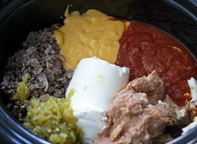 This slow cooker taco dip is perfect for parties - it can easily be thrown together in 2 hours with store bought ingredients! | honeyandbirch.com