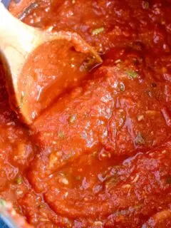 basil roasted garlic tomato sauce in a pot with a wooden spoon