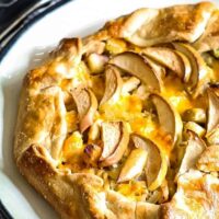 whole savory apple galette on a black and white plate