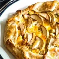 whole savory apple galette on a black and white plate