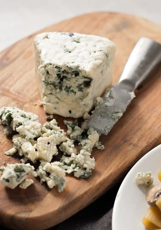 blue cheese triangle on a wood cutting board