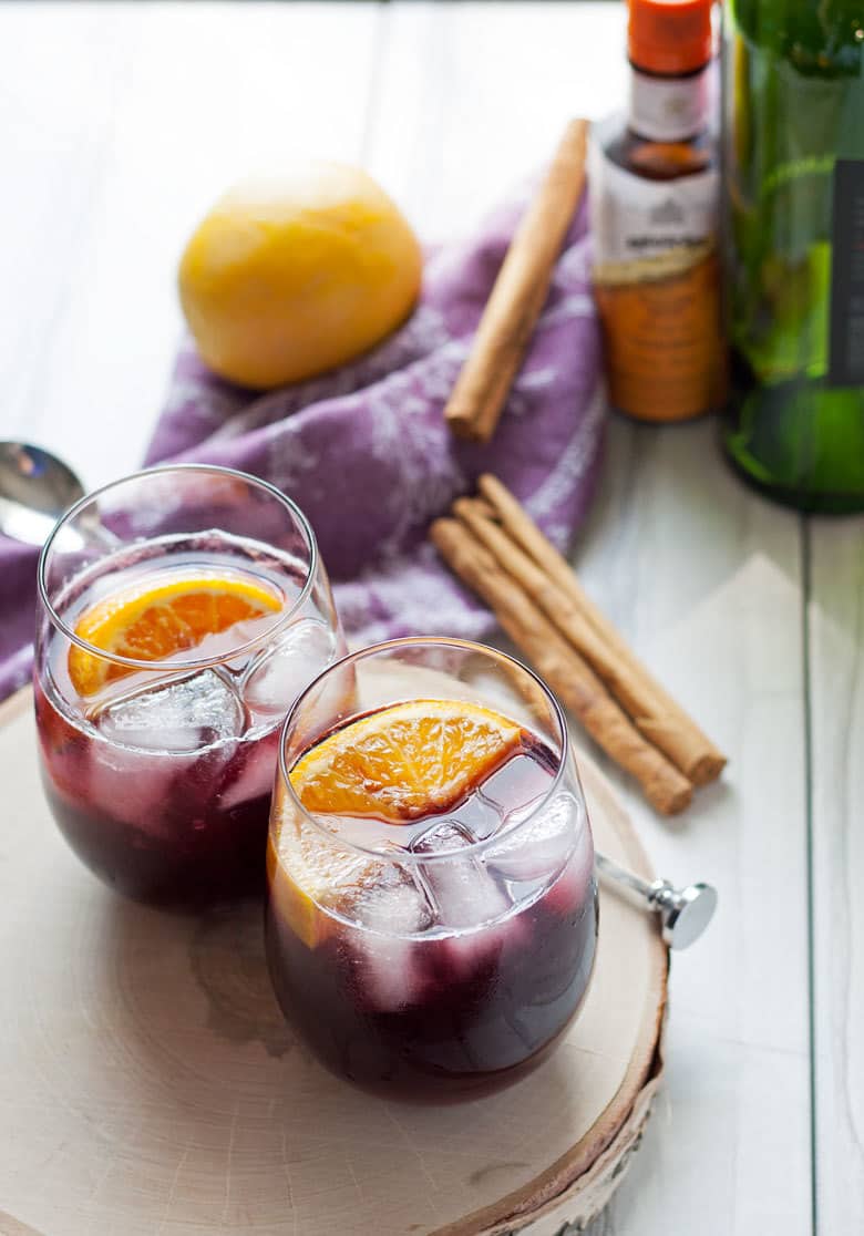 This orange red wine spritzer is a great cocktail for any season. Mix up a batch of cinnamon simple syrup, grab a bottle of your favorite red and try this drink today!