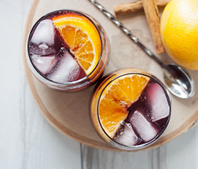 This orange red wine spritzer is a great cocktail for fall and winter. Mix up a batch of cinnamon simple syrup, grab a bottle of your favorite red and try this drink today! | honeyandbirch.com