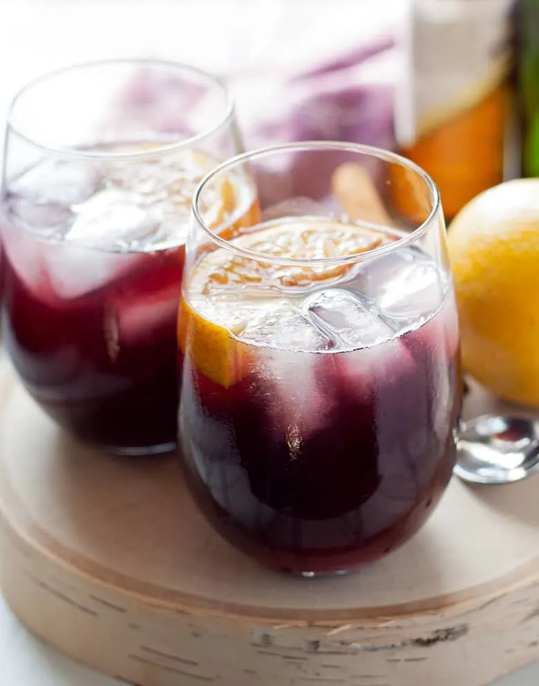 This orange red wine spritzer is a great cocktail for any season. Mix up a batch of cinnamon simple syrup, grab a bottle of your favorite red and try this drink today!