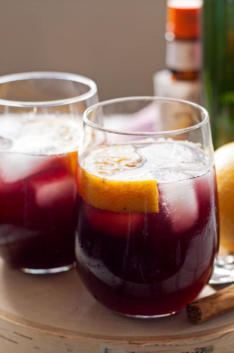 This orange red wine spritzer is a great cocktail for any season. Mix up a batch of cinnamon simple syrup, grab a bottle of your favorite red and try this drink today!