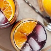 This orange red wine spritzer is a great cocktail for any season. Mix up a batch of cinnamon simple syrup, grab a bottle of your favorite red and try this drink today!