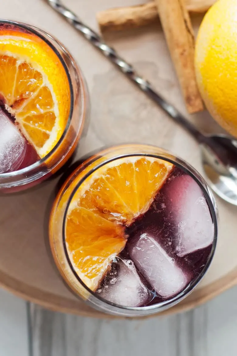 This orange red wine spritzer is a great cocktail for any season. Mix up a batch of cinnamon simple syrup, grab a bottle of your favorite red and try this drink today!
