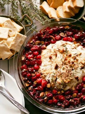 This fancy baked goat cheese roasted cranberry appetizer recipe is easier to make than it looks! It is the perfect appetizer for holiday gatherings like Thanksgiving and Christmas! | honeyandbirch.com