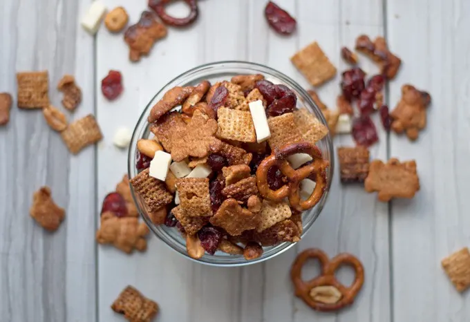 Try this cinnamon snack mix recipe - full of rice cereal, pretzels, graham crackers, cranberries and white chocolate! | honeyandbirch.com