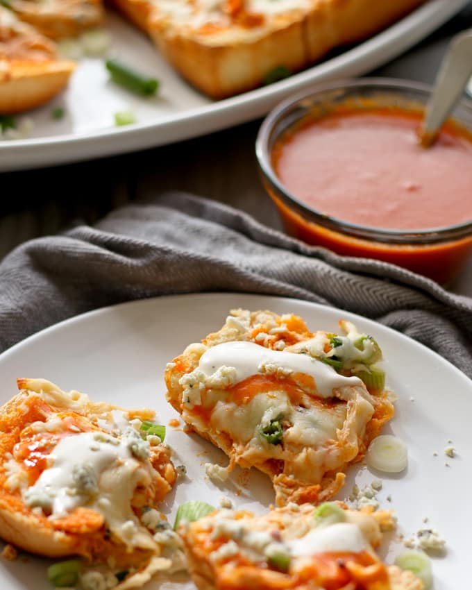 This buffalo chicken pizza bread recipe is going to be a hit at your next party! It's made with KING’S HAWAIIAN® Sweet Bread Rolls for easy eating and is the perfect appetizer or lunch! | honeyandbirch.com