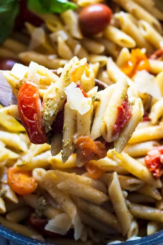 tomato and pesto pasta on a wooden spoon
