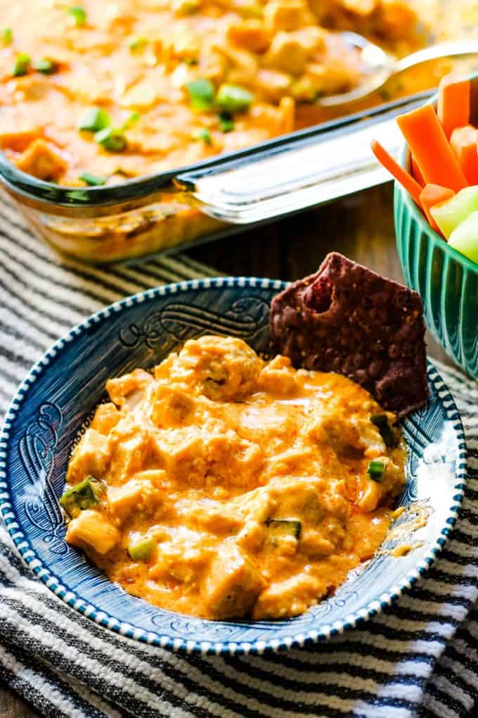 buffalo chicken dip in a blue bowl with a chip