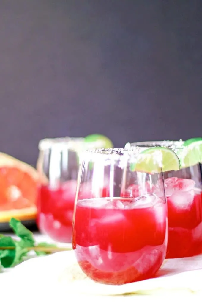 three grapefruit hibiscus margaritas grapefruit slices and fresh mint