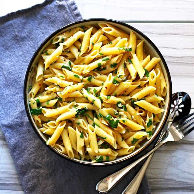 pasta aglio e olio on a marble table with a blue napkin