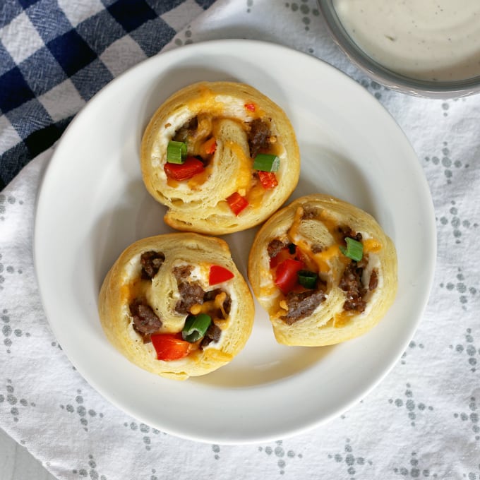 If you're looking for game day food, this sausage pinwheel appetizer is going to be your new favorite recipe for tailgating season. It's made with sausage, refrigerated crescent rolls, red bell peppers and two types of cheese;it's an easy and delicious appetizer to add to your party. Just serve it with a little ranch! | honeyandbirch.com