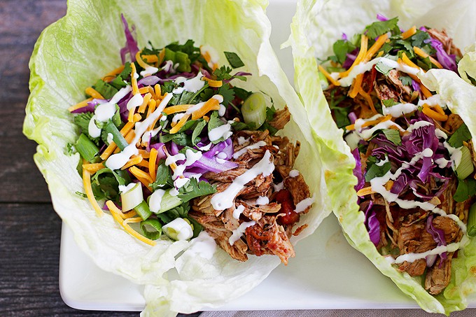 These slow cooker chicken taco lettuce wraps are going to be your new favorite taco recipe. Make the chicken taco meat in the slow cooker and substitute iceberg lettuce leaves for tortilla shells! | honeyandbirch.com