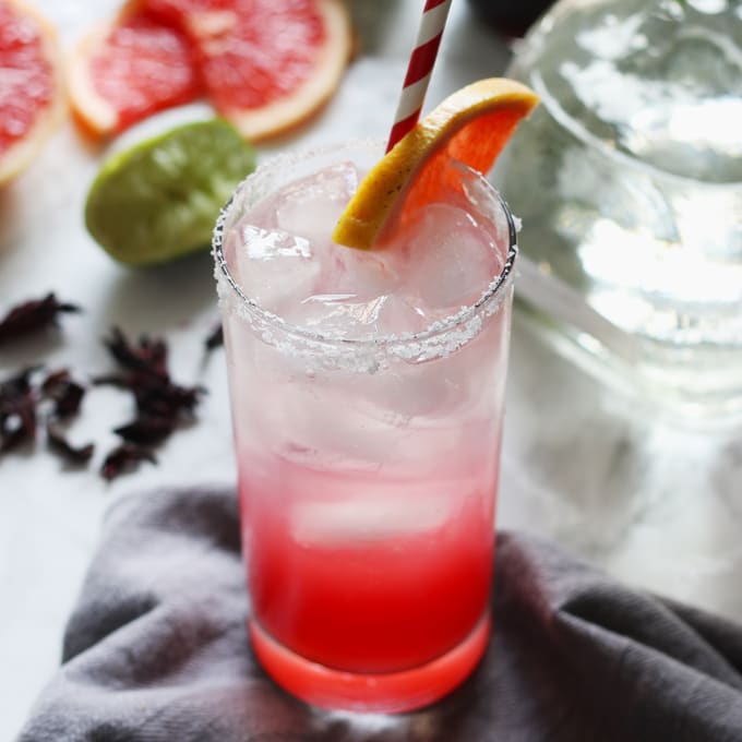 This hibiscus paloma cocktail is a refreshing recipe; the tart grapefruit and lime juices are well complemented by the sweet floral hibiscus simple syrup. Break out that bottle of tequila and mix up a batch of these drinks today! | honeyandbirch.com