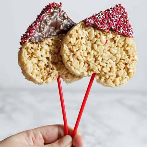 These rice krispie pops are the perfect easy Valentine's Day treat for you and your kids! Whip up a batch of rice krispie treats, dip them in chocolate and apply sprinkles! | honeyandbirch.com