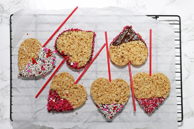 These rice krispie pops are the perfect easy Valentine's Day treat for you and your kids! Whip up a batch of rice krispie treats, dip them in chocolate and apply sprinkles! | honeyandbirch.com