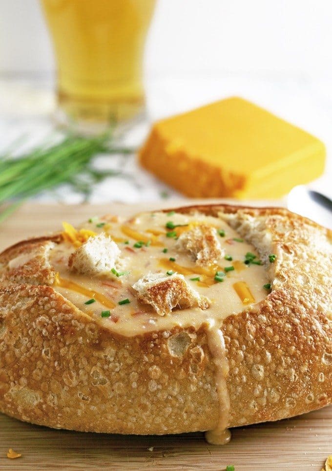 This slow cooker beer cheese soup is super easy to make! It combines sharp cheddar cheese, cream cheese and beer and is delicious for lunch or dinner. Serve it with crusty bread or like me, in a sour dough bread bowl! | honeyandbirch.com