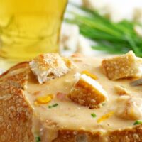 This slow cooker beer cheese soup is super easy to make! It combines sharp cheddar cheese, cream cheese and beer and is delicious for lunch or dinner. Serve it with crusty bread or like me, in a sour dough bread bowl! | honeyandbirch.com